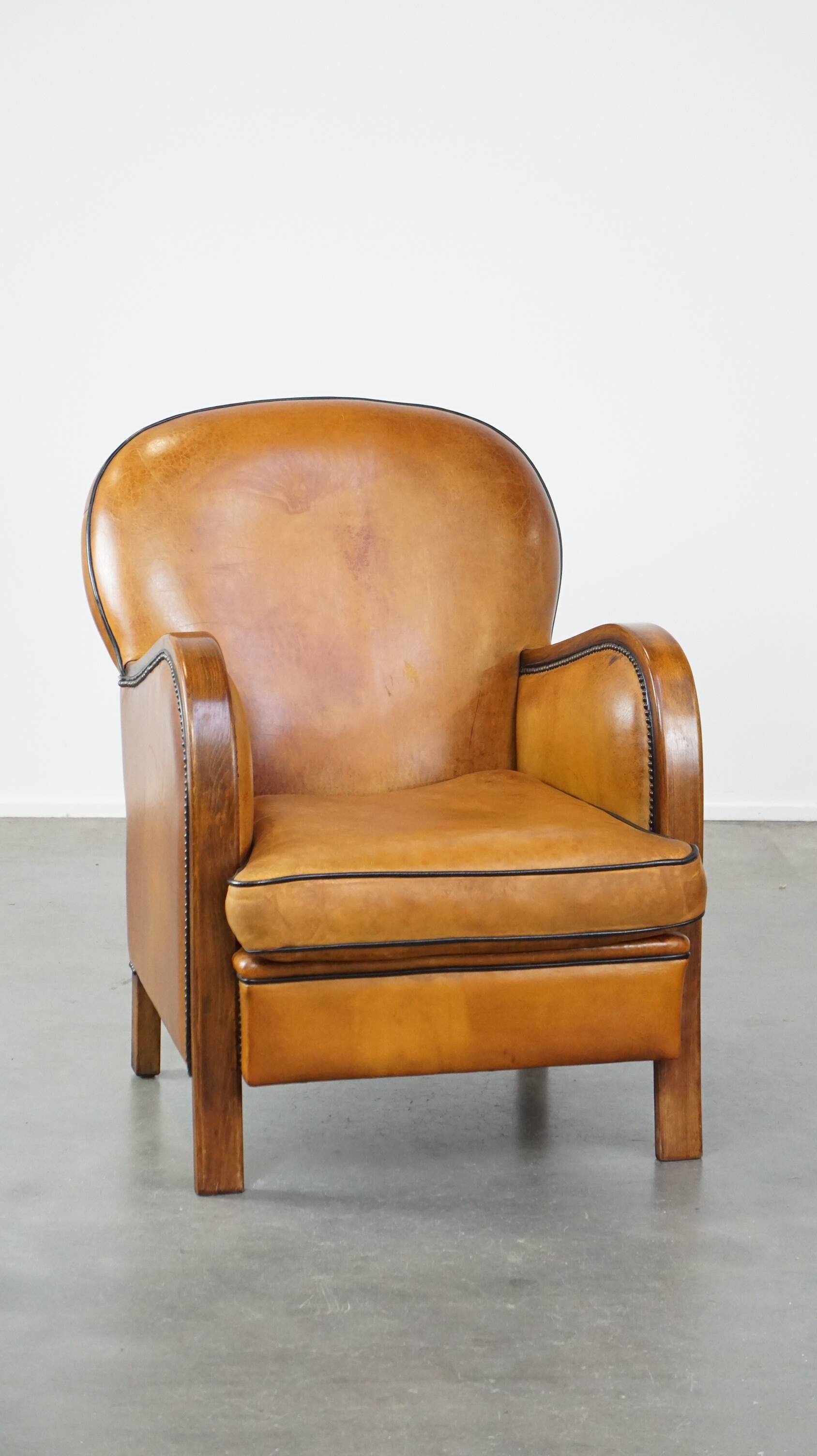 Unique, luxurious sheepskin armchair combined with wood and finished with decorative nails