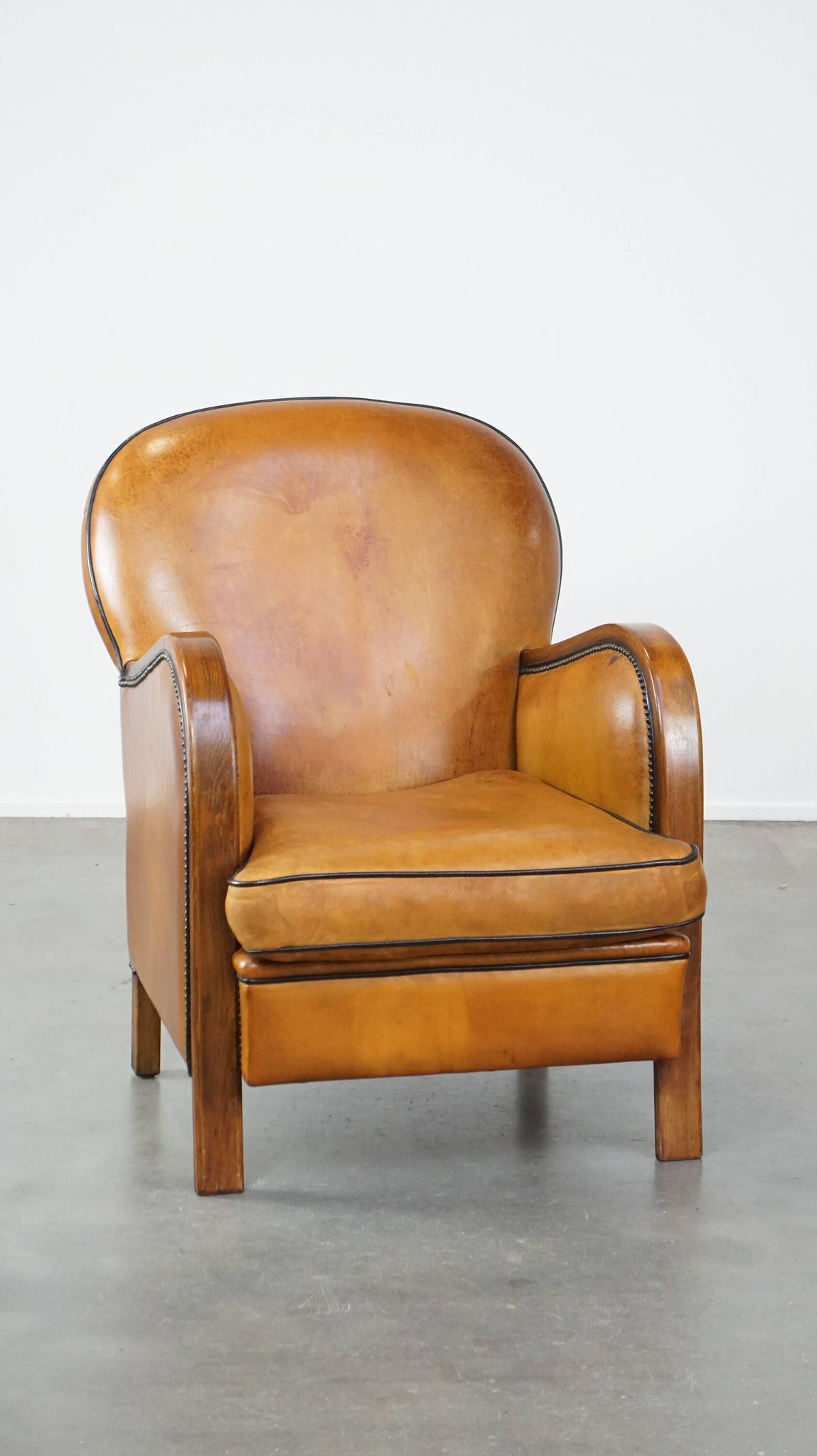 Unique, luxurious sheepskin armchair combined with wood and finished with decorative nails