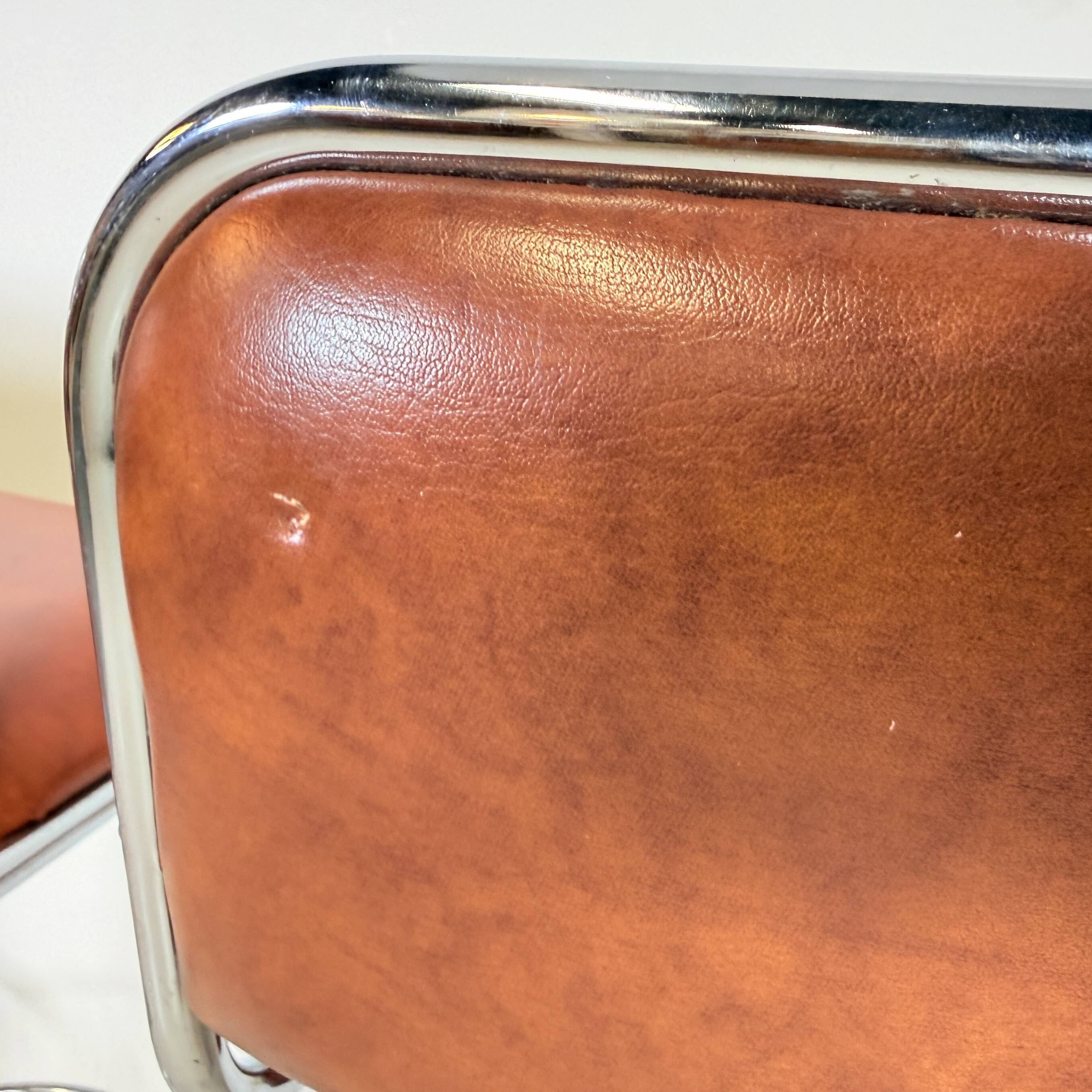1970s chrome bar stools with cognac-colored faux leather upholstery