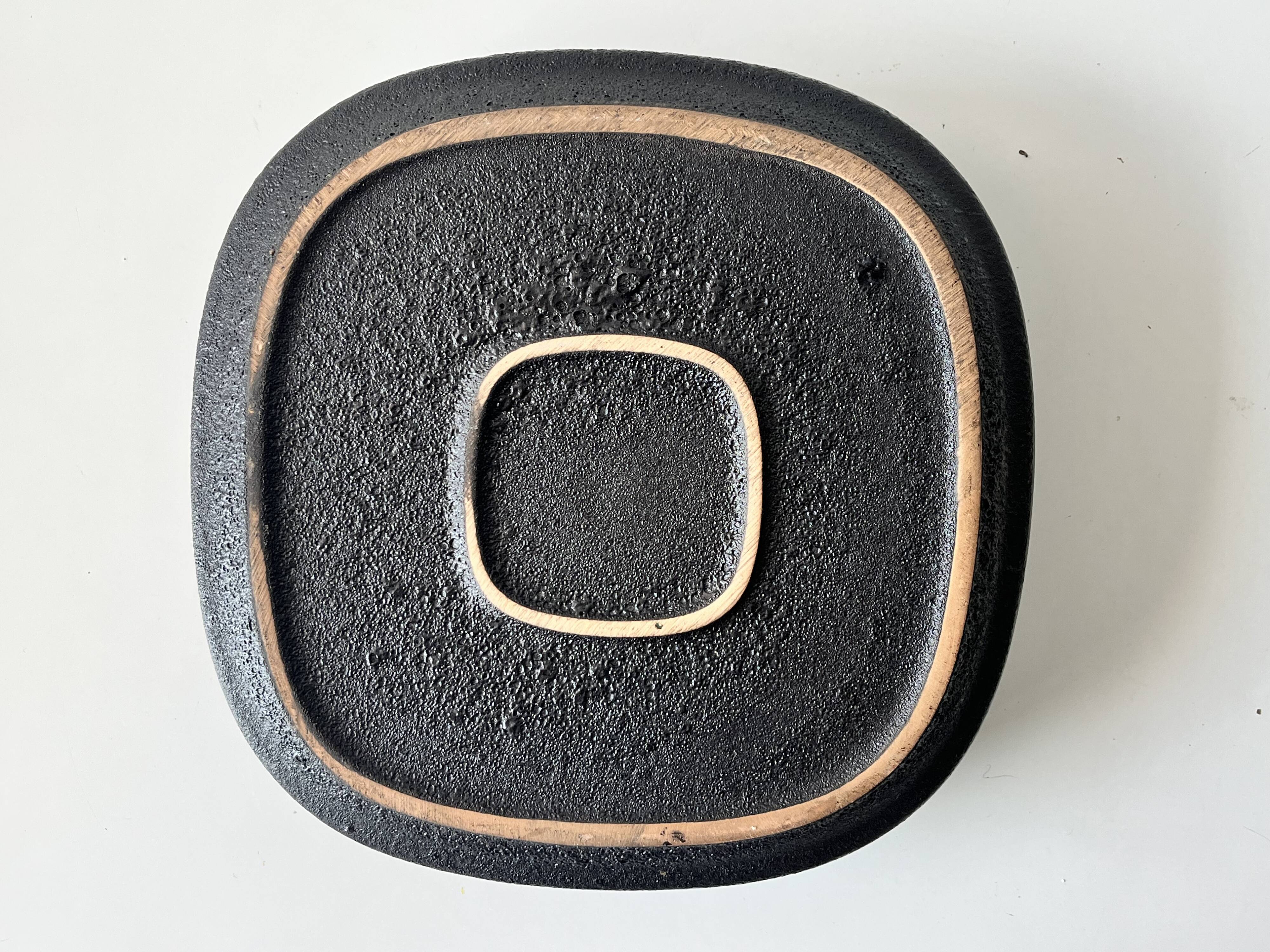 Large decorative ceramic catchall with red and black spiral pattern.