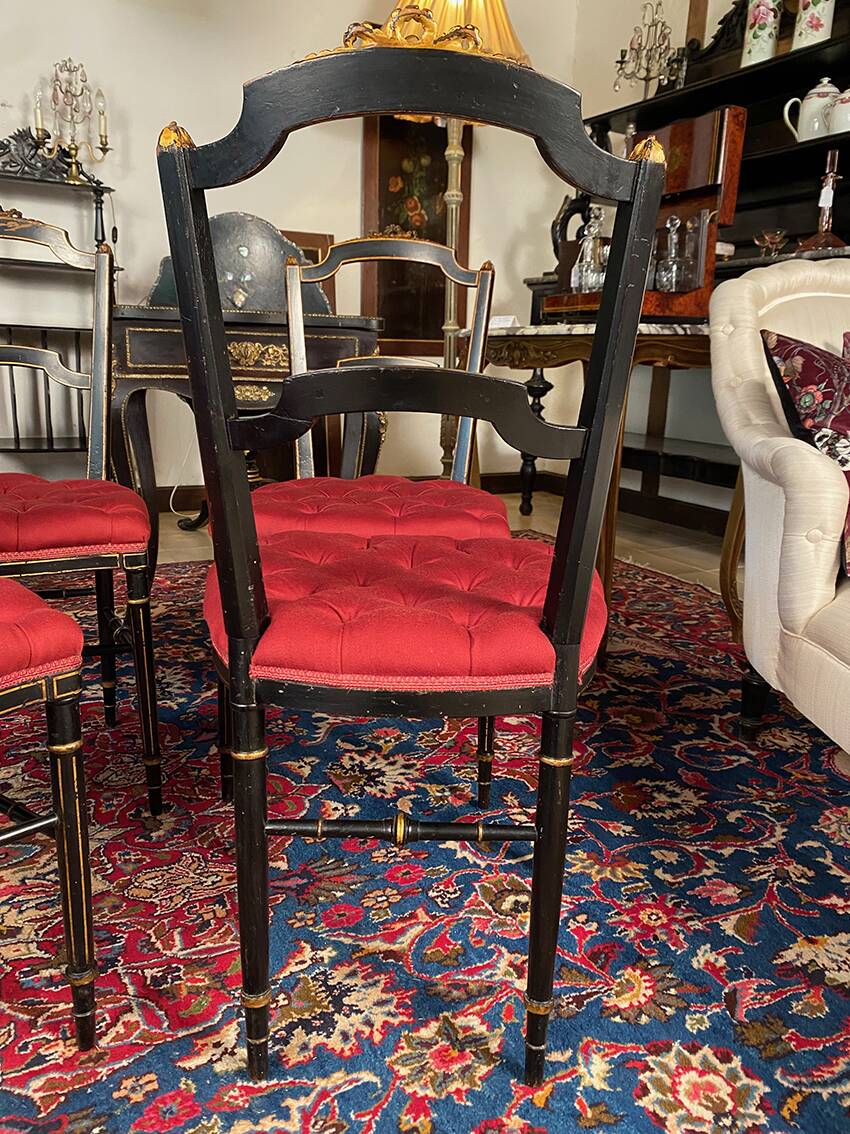Set of four Napoleon III chairs in black lacquered wood with gold highlights.