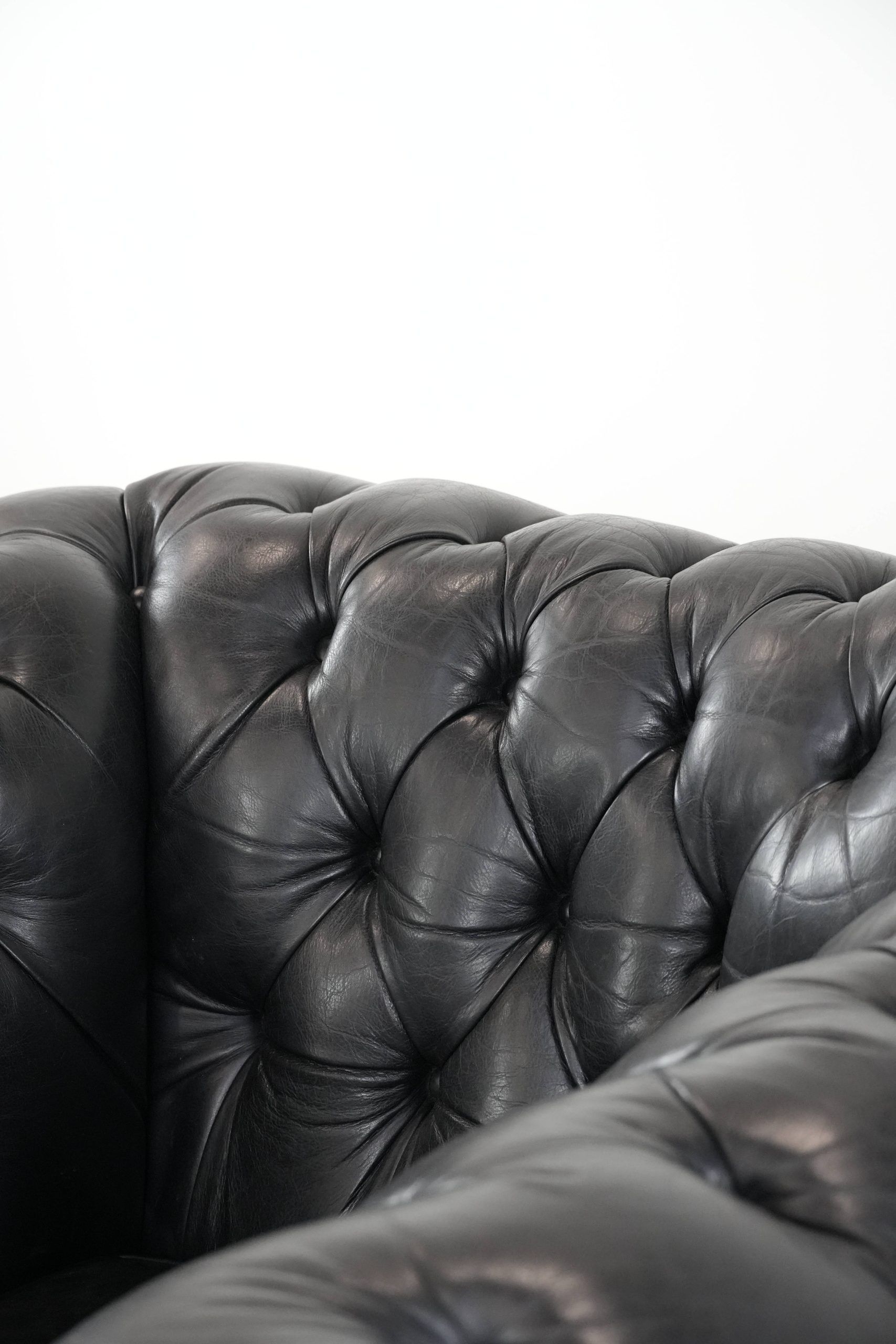 Comfortable black chesterfield armchair made of cowhide leather