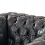 Comfortable black chesterfield armchair made of cowhide leather