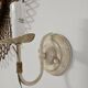 Pair of cream patinated metal wall sconces with floral decoration.