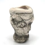 Ceramic vase sculpture decorated with faces and featuring a hole, 1980s.