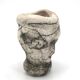 Ceramic vase sculpture decorated with faces and featuring a hole, 1980s.