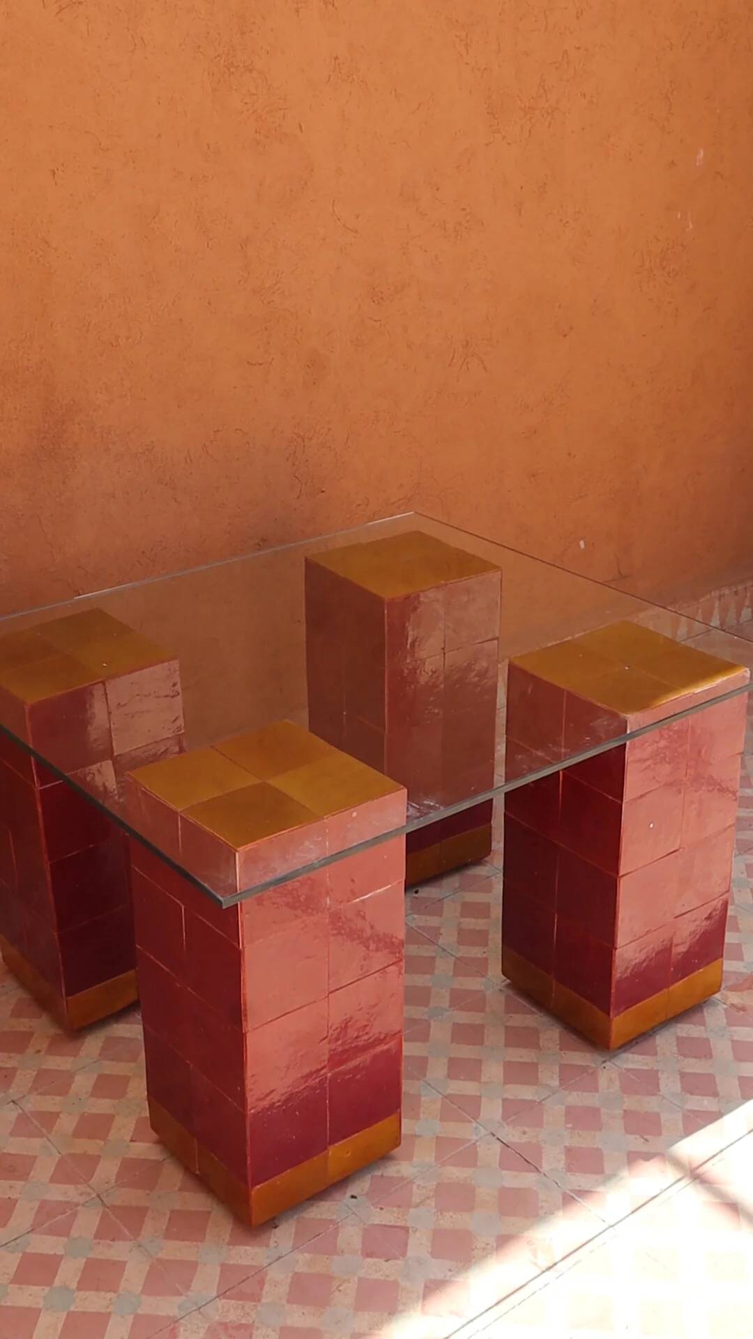 Modern coffee table in burgundy zellige with a tempered glass top.