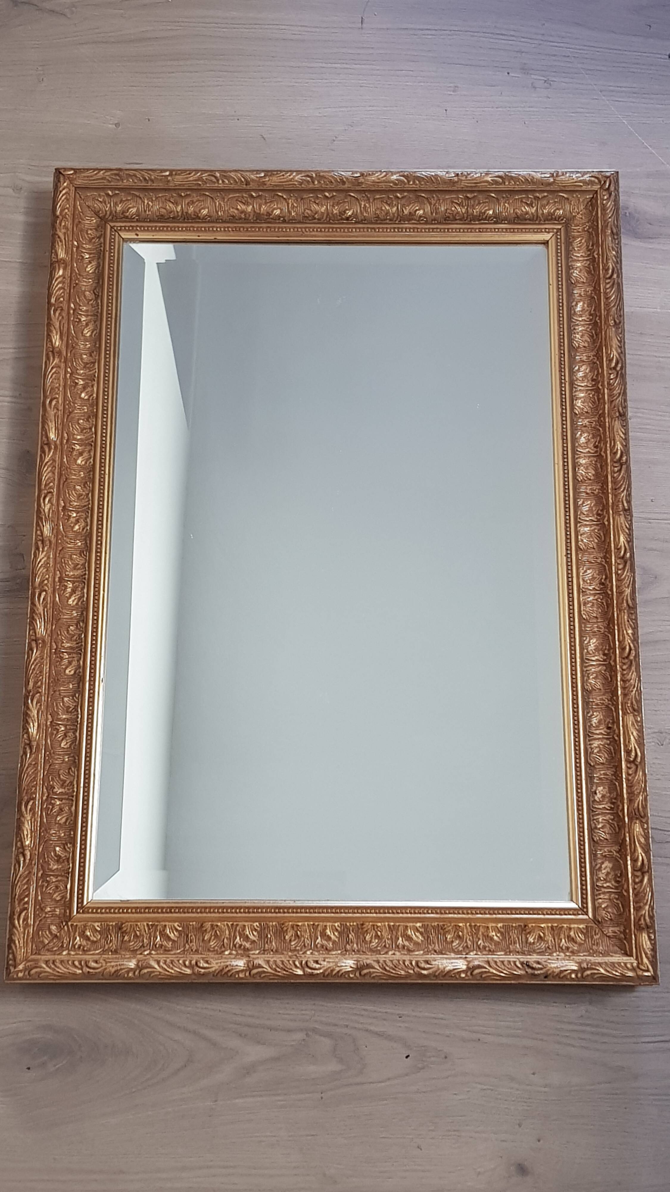 Mirror in gilded stucco wood and beveled glass