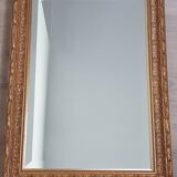 Mirror in gilded stucco wood and beveled glass