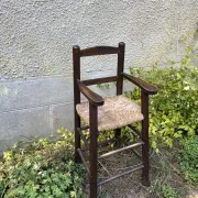 Vintage wooden children's high chair with straw.