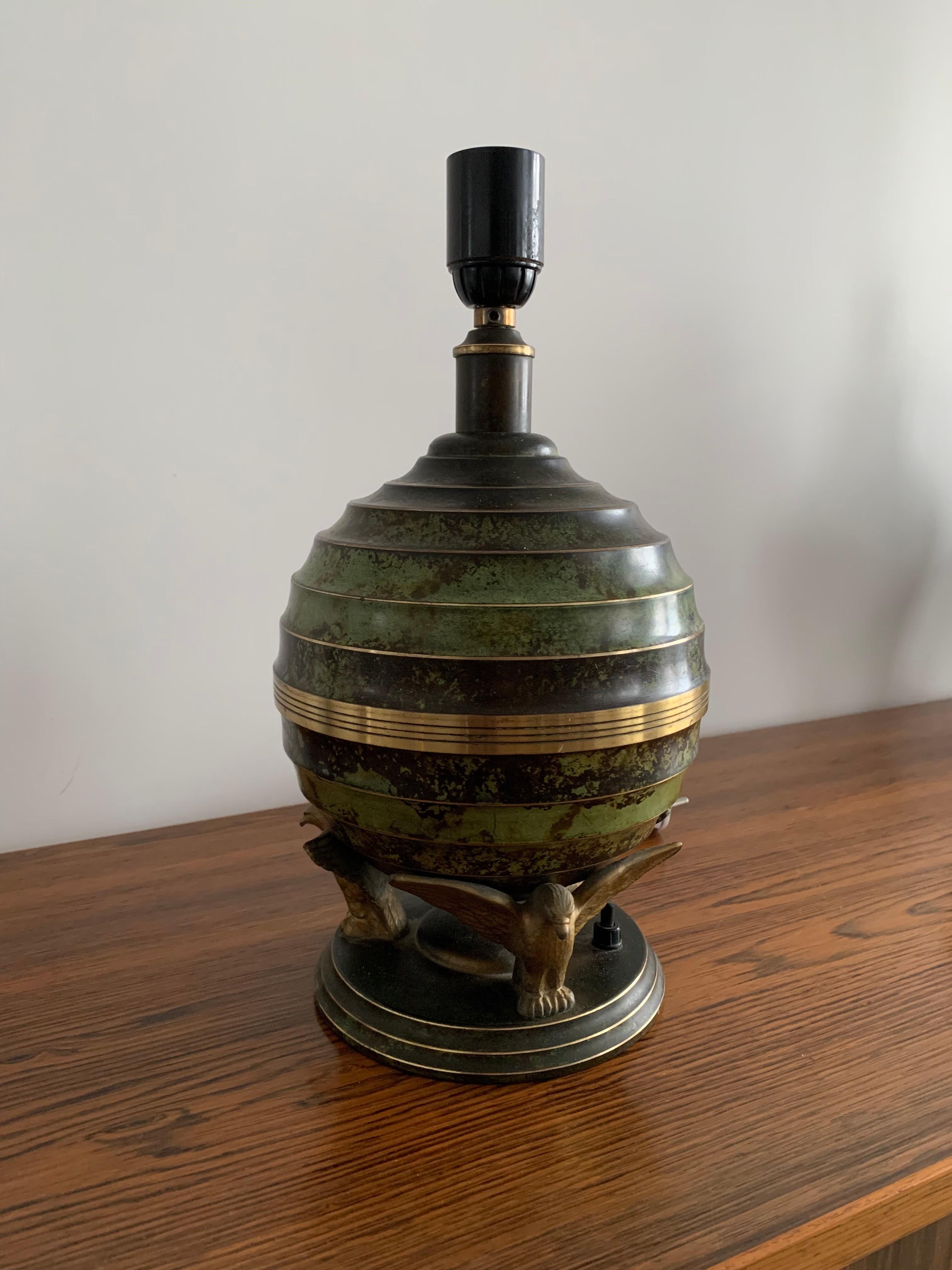 Art Deco table lamp in patinated bronze with eagles holding a globe, France 1940.