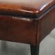 Large dark brown square ottoman made of sheepskin with black piping