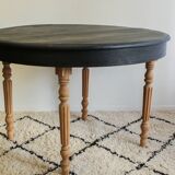 Round black dining table with oak wood.