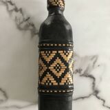 Ethnic decorative bottle in leather and raffia braiding