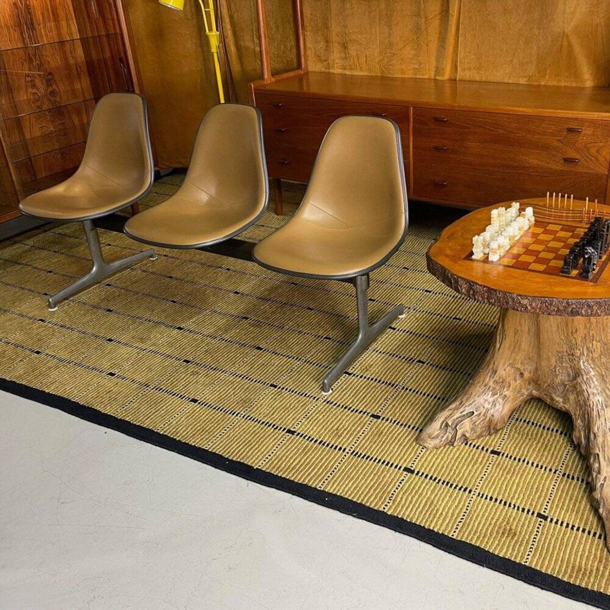 Tandem bench with brown Naugahyde pad shell chairs by Charles and Ray Eames for Herman Miller