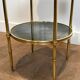 Round bronze side table with triple shelves of églomisé mirrors from Maison Baguès