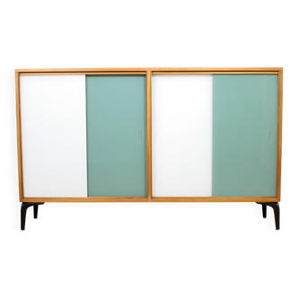 Une bibliothèque/buffet vintage du milieu du siècle avec une porte coulissante verte et blanche