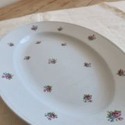 Antique oval serving dish in pale blue earthenware with a small flower design.