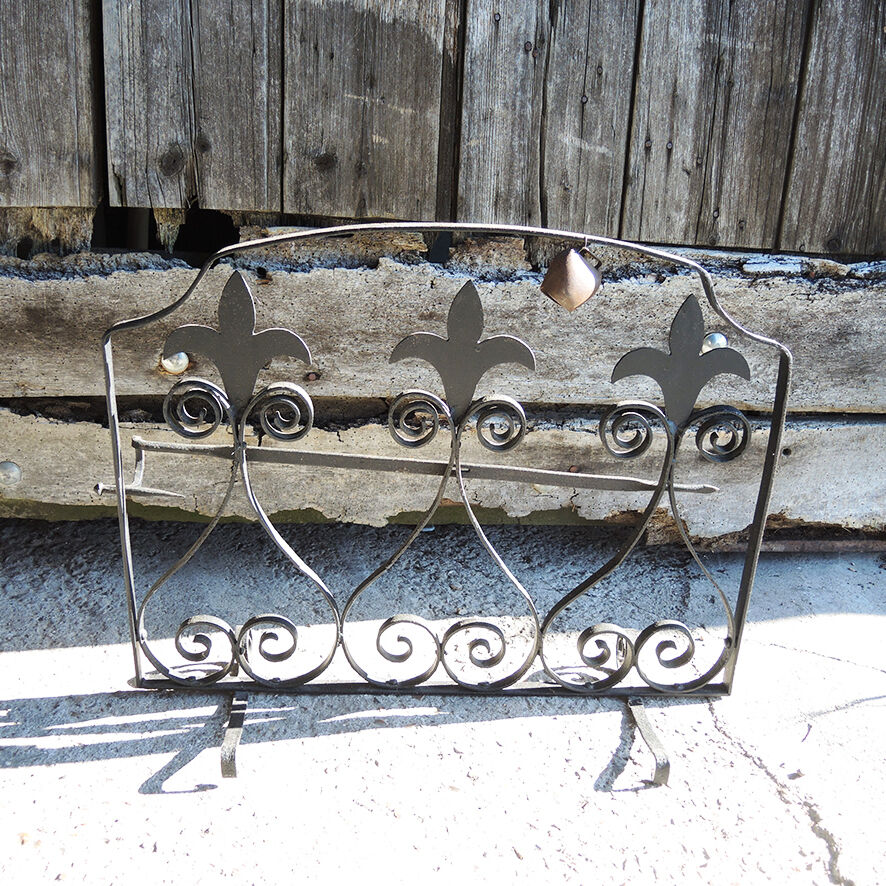 Old wrought iron fleur-de-lis fire screen