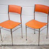 Pair of chrome metal chair and orange skai