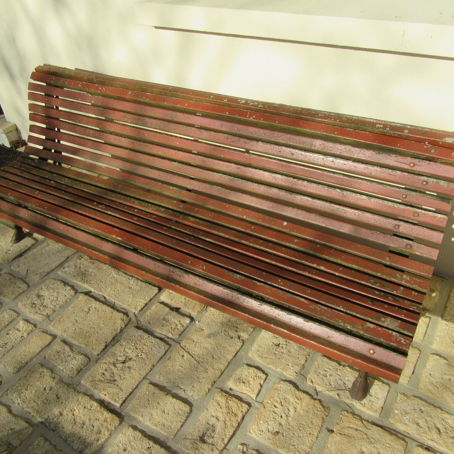 Public bench in wooden slats and cast iron legs