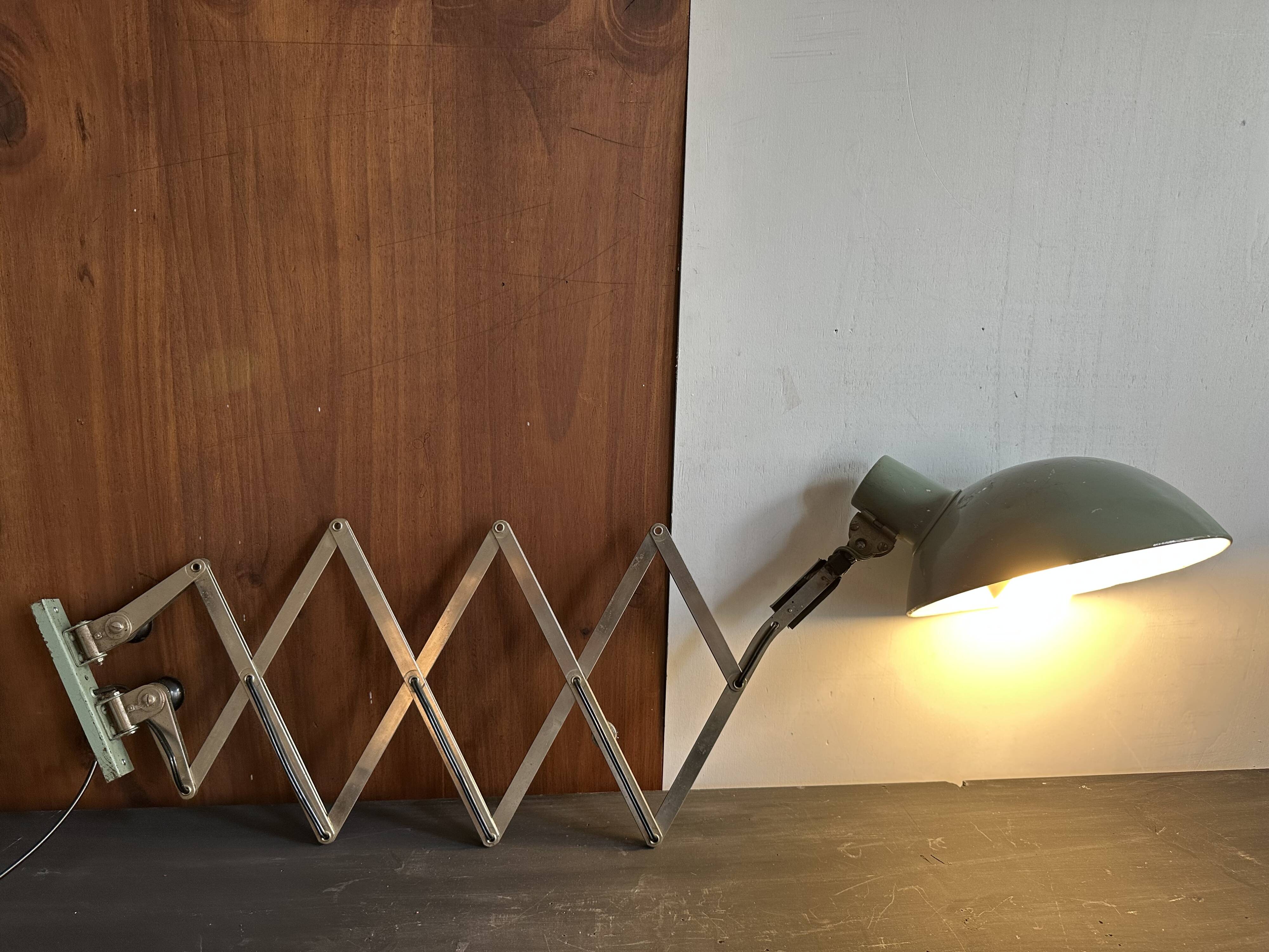 Old extendable accordion lamp in celadon green, workshop spirit.