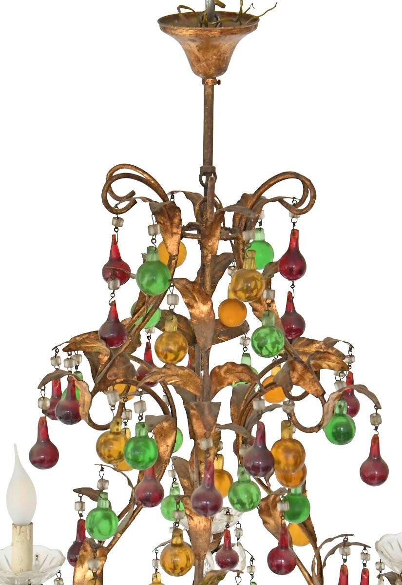 Lustrous chandelier with two wall lights decorated with foliage and pendants.