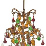 Lustrous chandelier with two wall lights decorated with foliage and pendants.