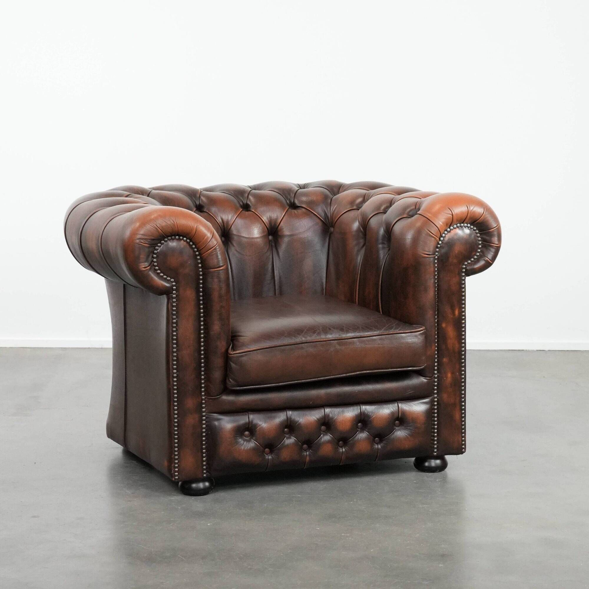 Brown Chesterfield armchair made of cowhide leather in English style