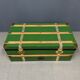 Green metal trunk with wooden sleds
