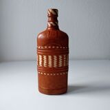 Vintage glass bottle covered with light brown leather and wicker