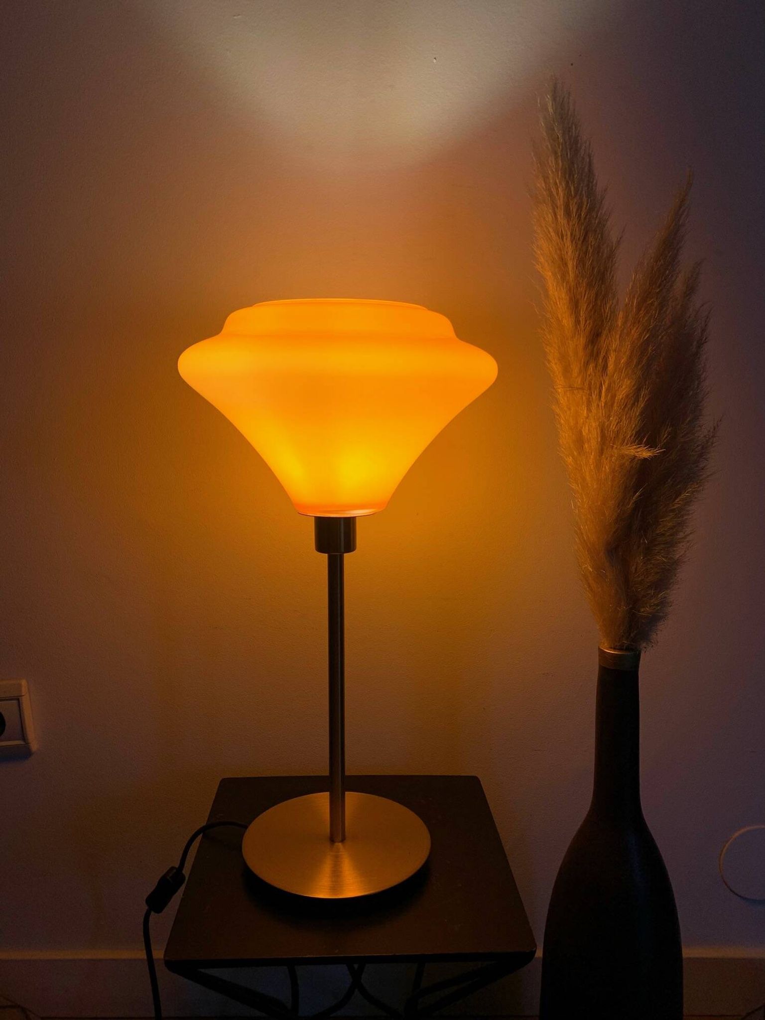 Table lamp with a vintage orange glass globe and a gold base