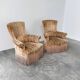 Pair of sculptural Hollywood Regency lounge chairs with original fringed upholstery