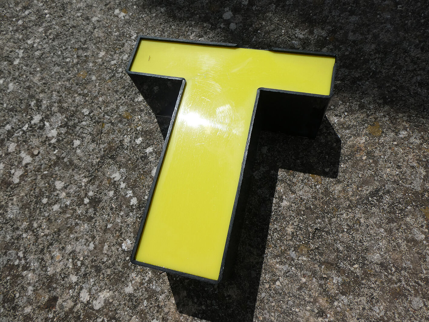 Lettre T d'enseigne industrielle jaune et noire