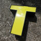Lettre T d'enseigne industrielle jaune et noire