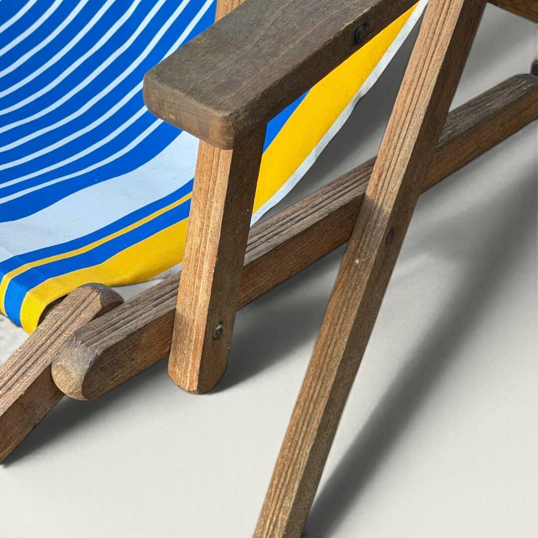 Vintage deck chair with blue and yellow striped fabric, original patina.