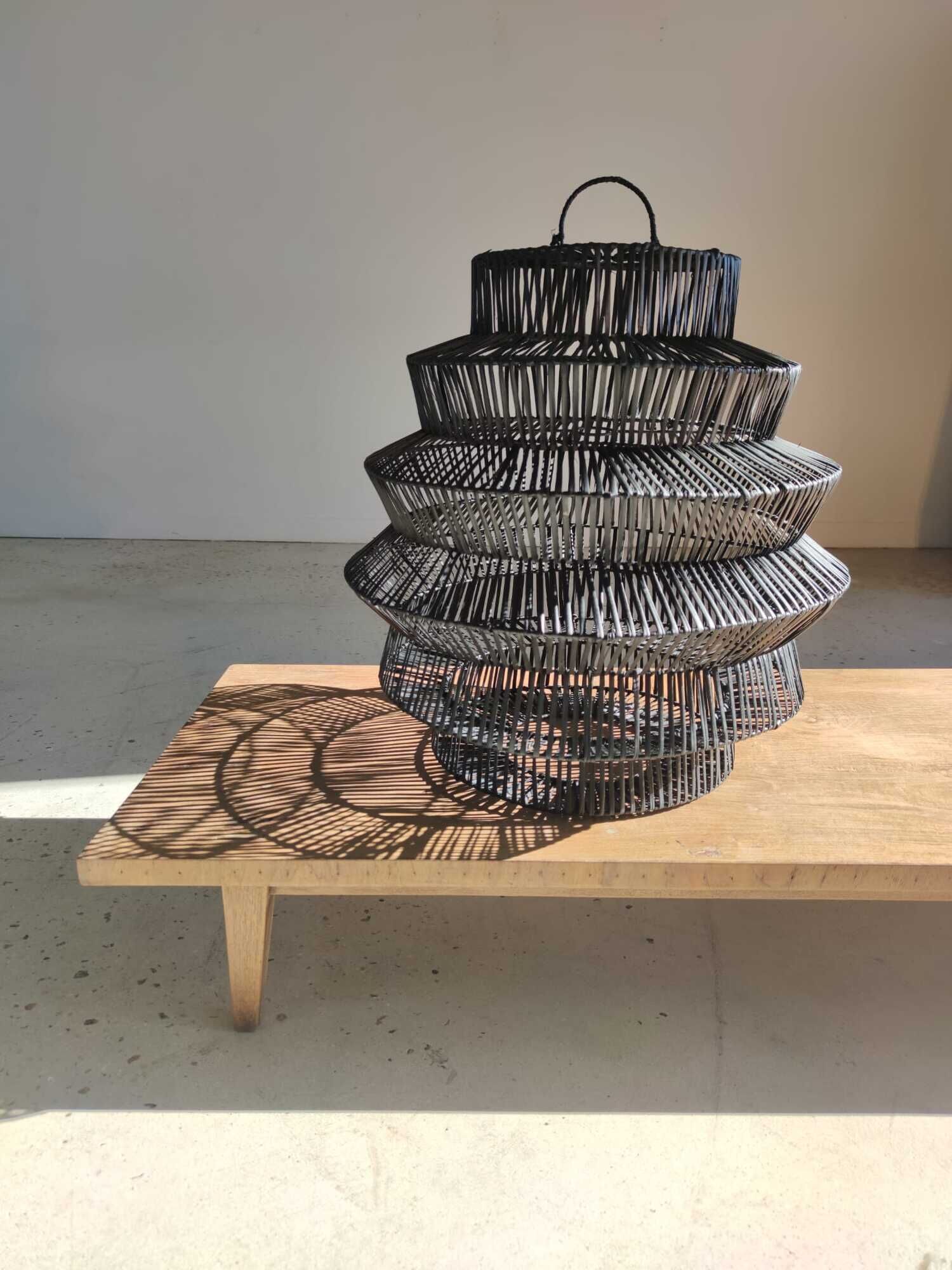 Braided rattan suspension in the shape of a black accordion