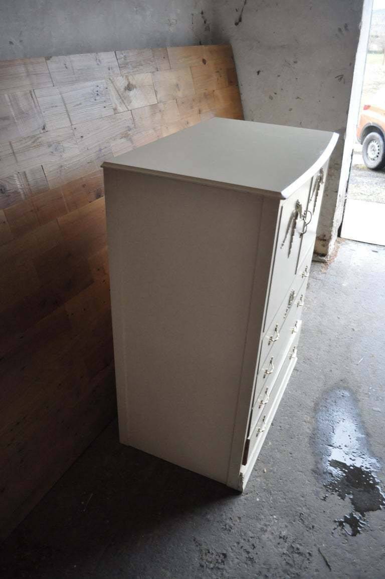 Mid-century wooden dresser painted in cream white, with 2 doors and 4 drawers, brass fittings.