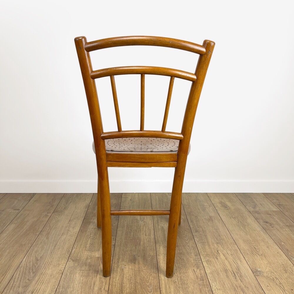 Pair of curved wood bistro chairs and studded and perforated seat