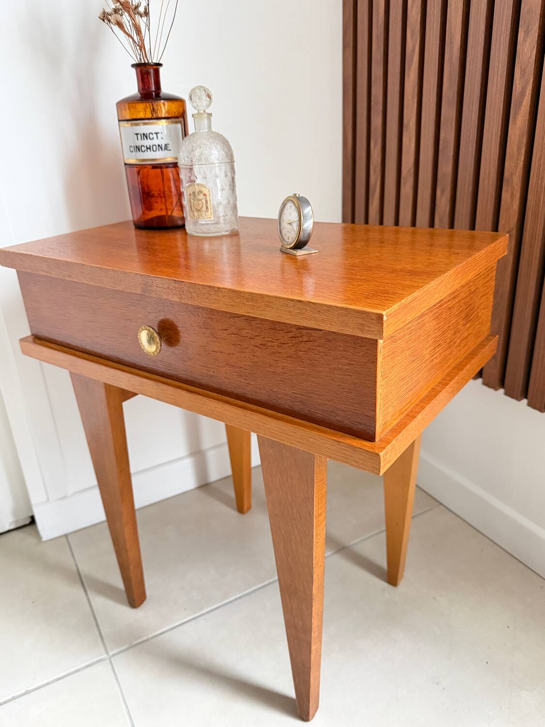 Vintage bedside table with tapered legs.