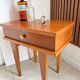 Vintage bedside table with tapered legs.