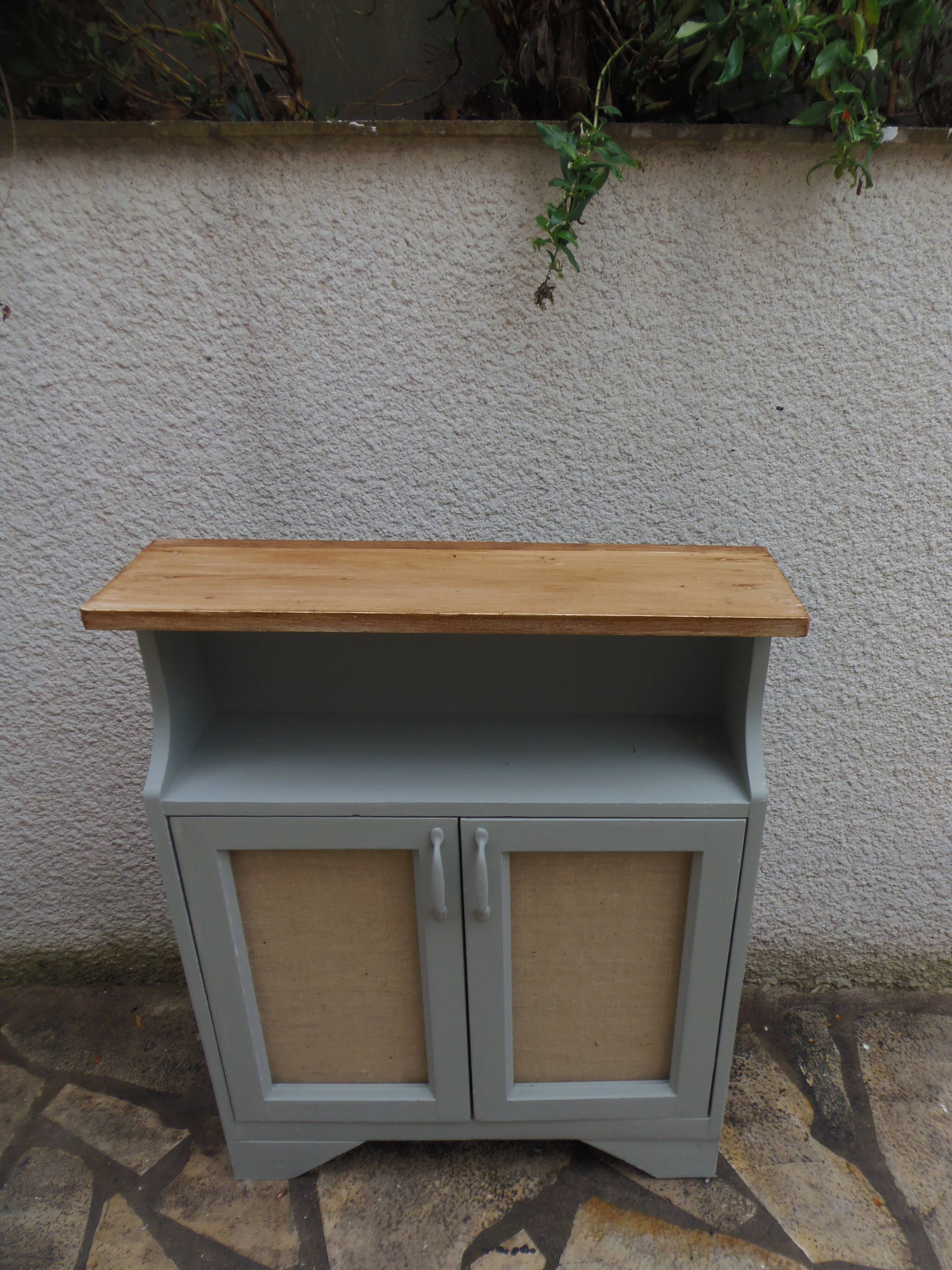 Small vintage green-grey piece of furniture, with 2 doors covered in burlap.