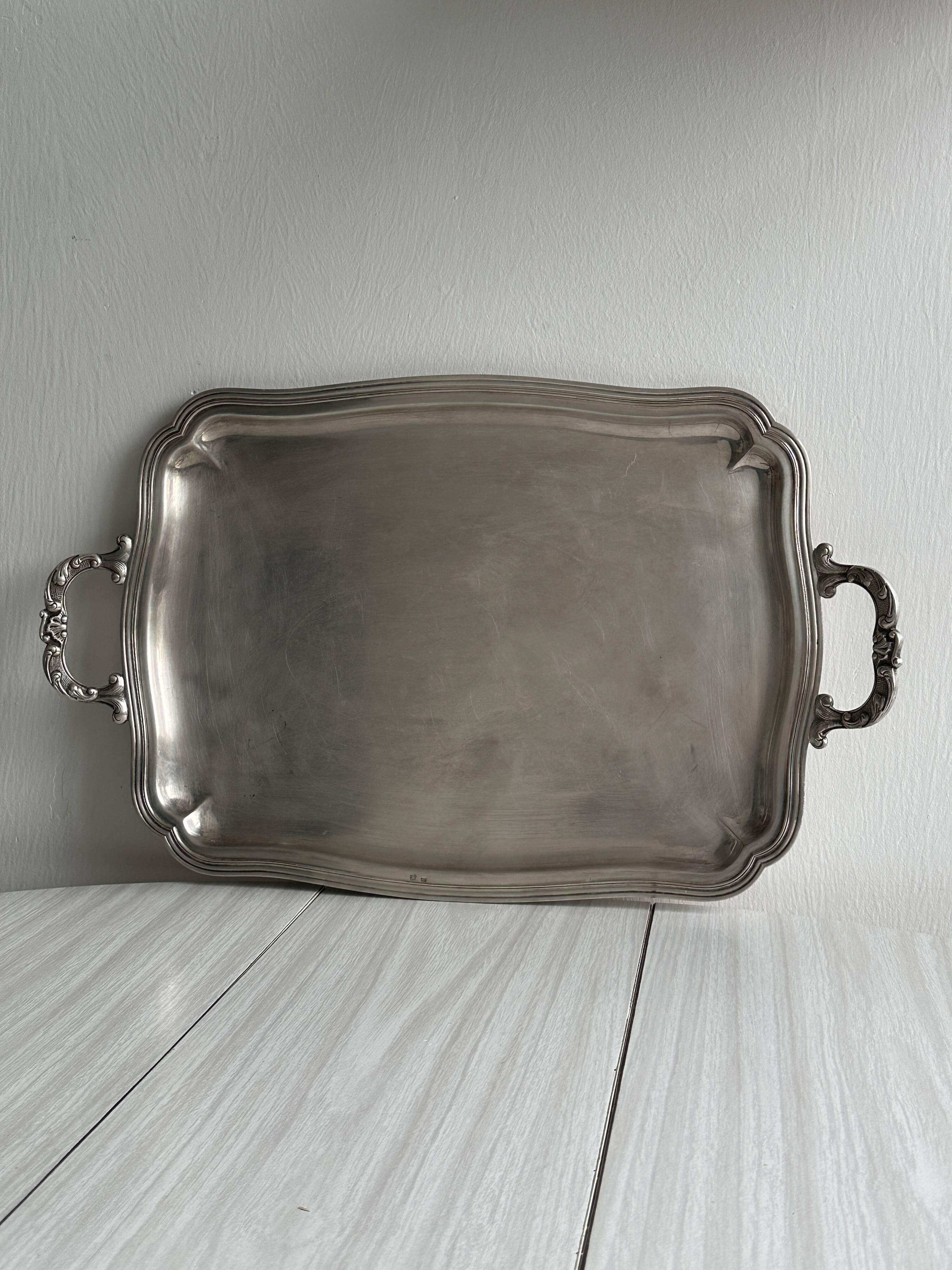 Silver metal serving tray with sculpted handles