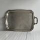 Silver metal serving tray with sculpted handles