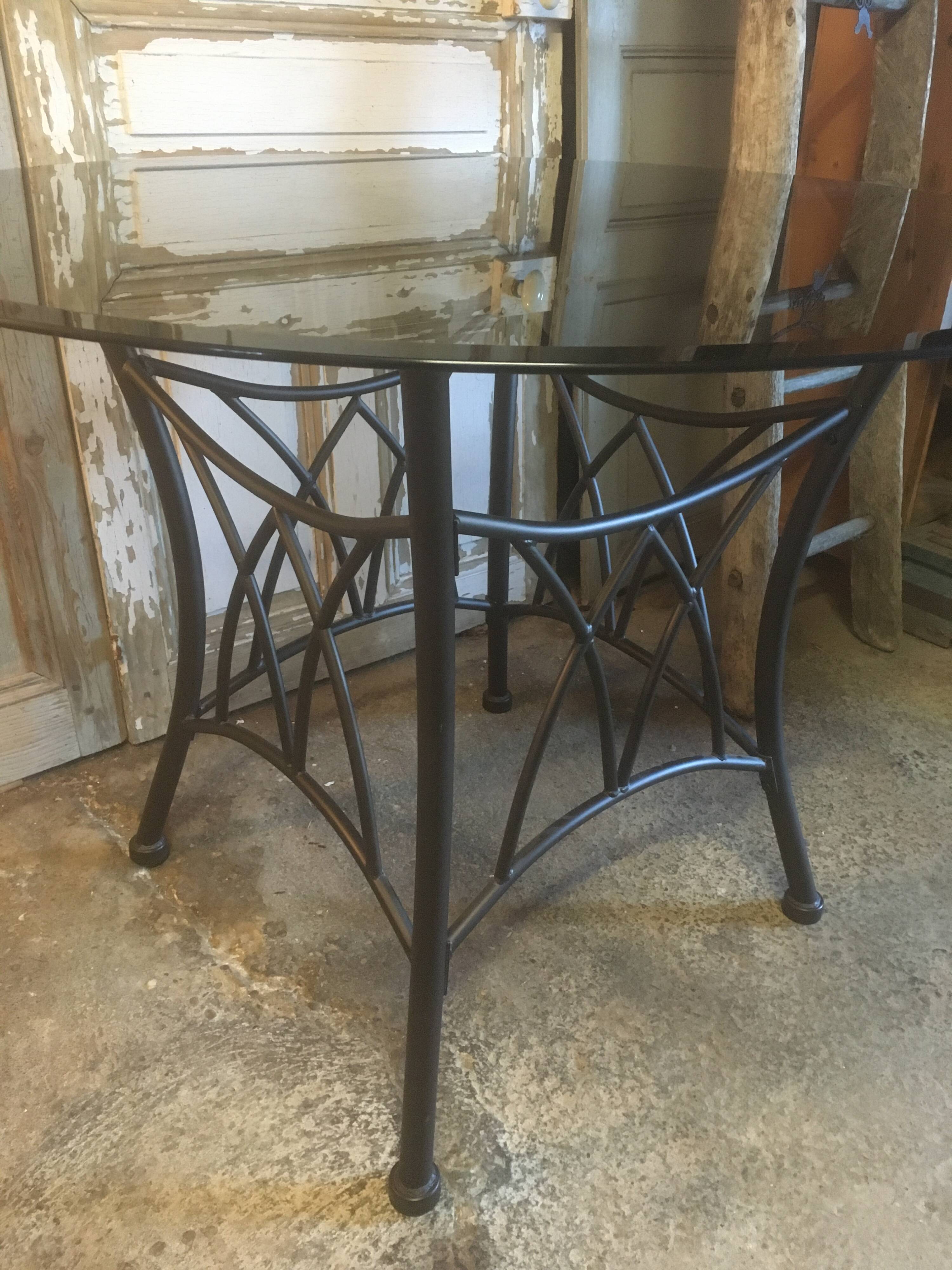 Round table with metal legs and smoked glass