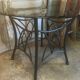 Round table with metal legs and smoked glass.