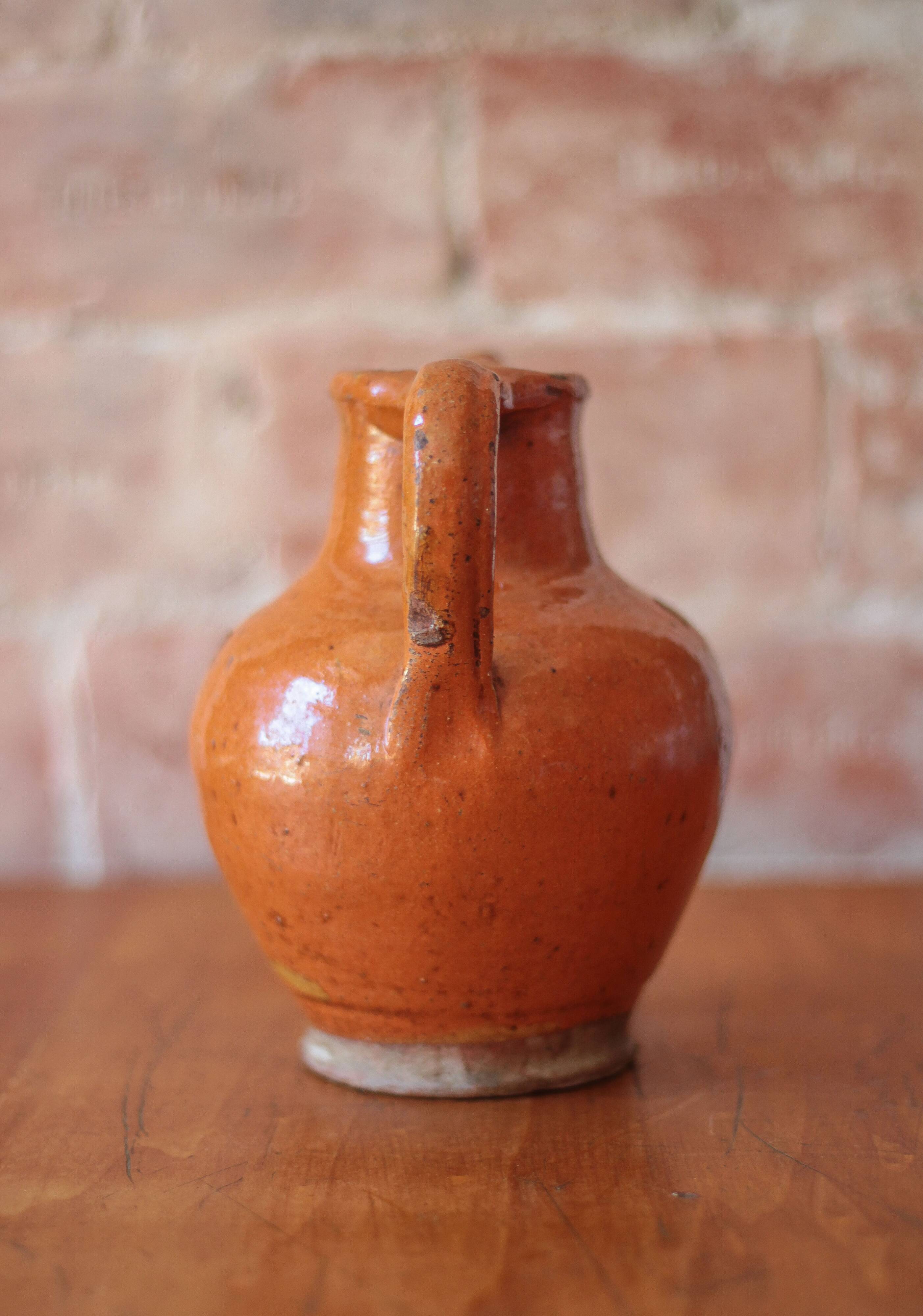 Ancient Orjol jug in orange glazed terracotta from South West France, 19th century.