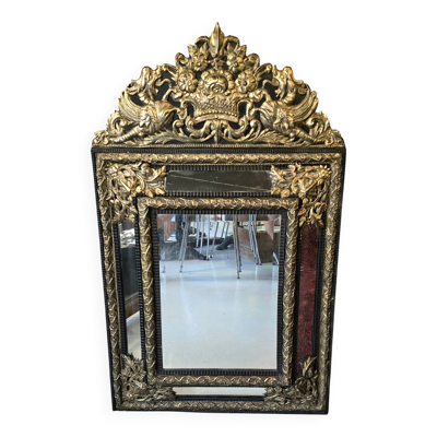Miroir à parecloses en bois noirci et métal repoussé doré style Louis XIV,