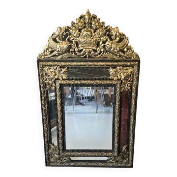 Miroir à parecloses en bois noirci et métal repoussé doré style Louis XIV,