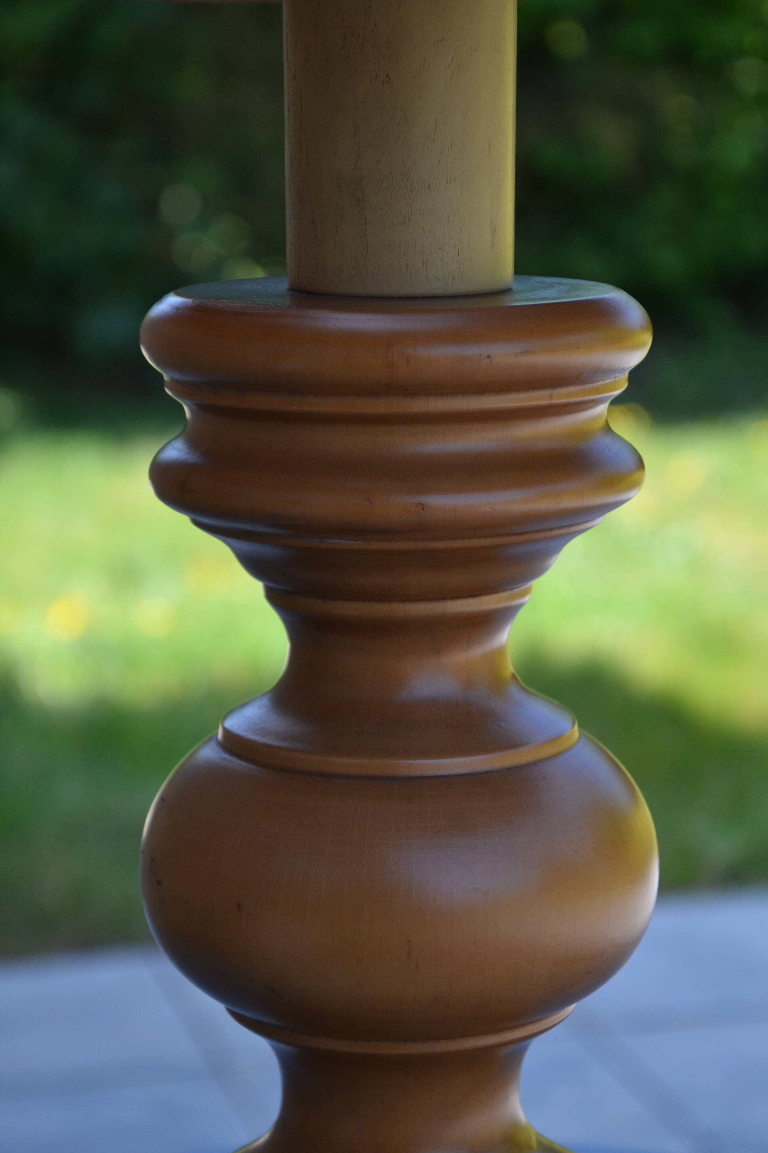 Large wooden lamp with a woven rattan shade.